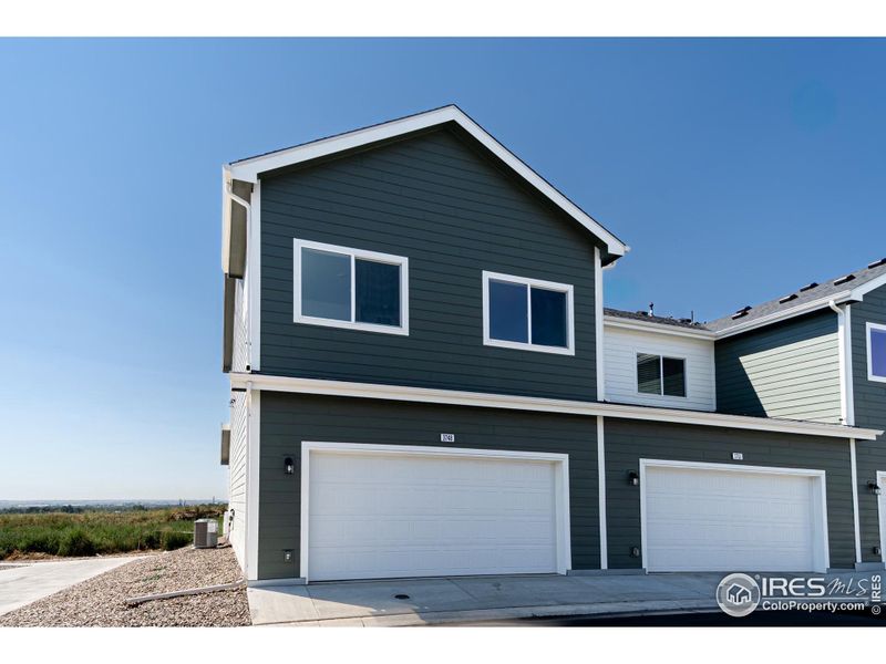 Front exterior of a new home in Liberty Draw, Evans, CO, highlighting curb appeal (Image 1).