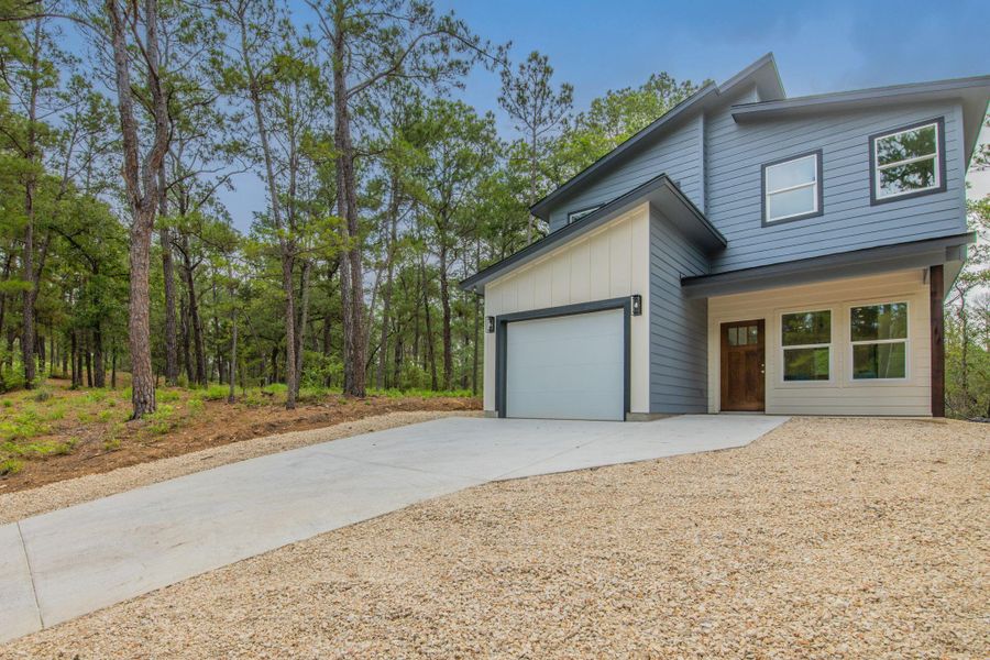 Contemporary architectural design featuring a multi-pitched roofline and a mix of blue and cream-colored siding Contemporary architectural design featuring a multi-pitched roofline and a mix of blue and cream-colored siding