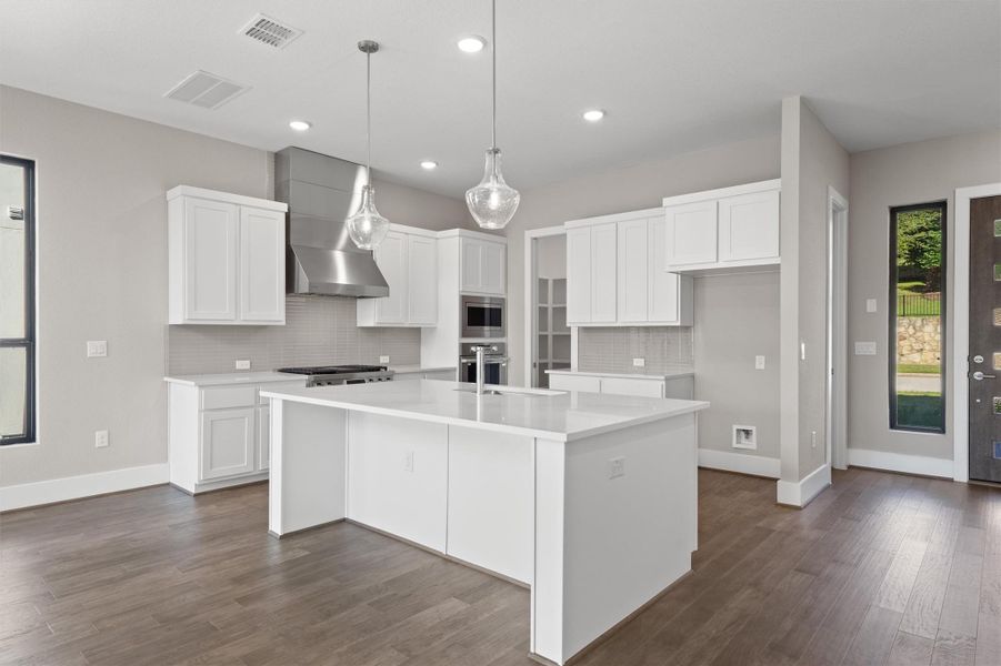 A well-appointed kitchen features a large central island and modern appliances. A well-appointed kitchen features a large central island and modern appliances.