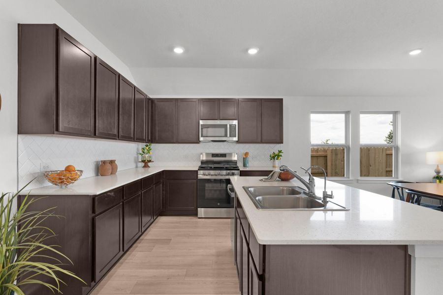 A well-appointed kitchen showcasing rich cabinetry, sleek countertops, and stainless steel appliances.