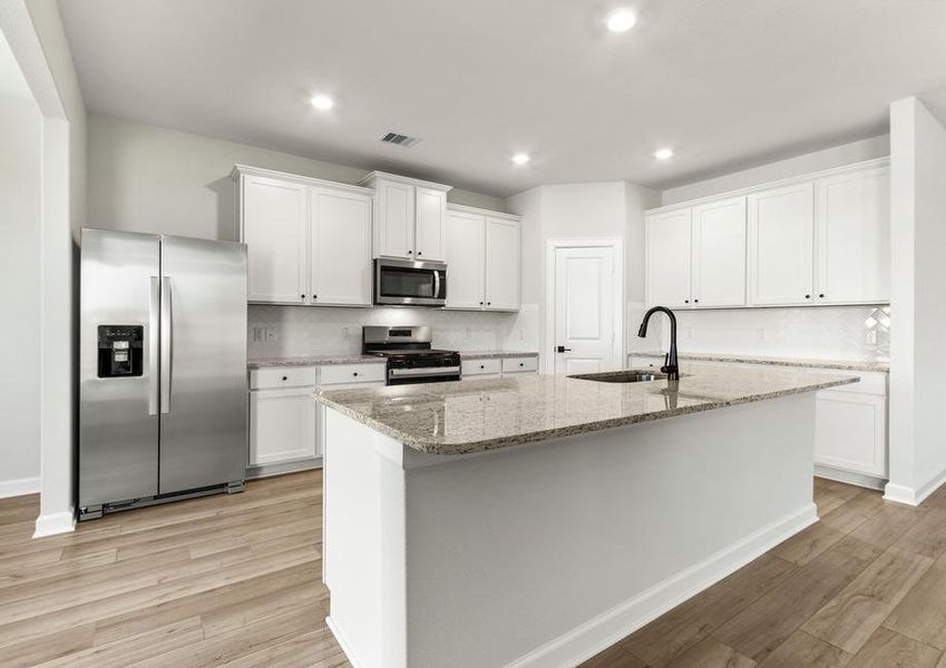 Chef-ready kitchen with white backsplash and granite countertops