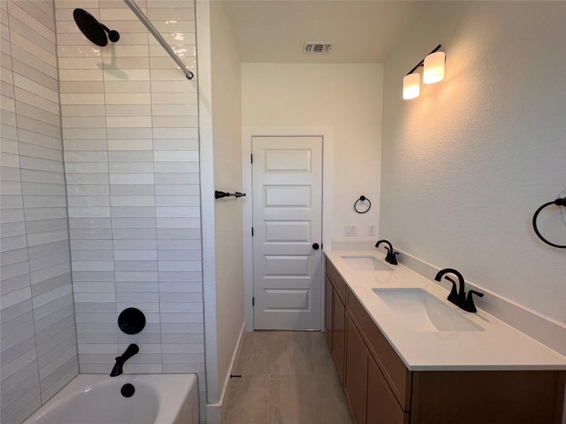Full bath with double vanity and shower / washtub combination