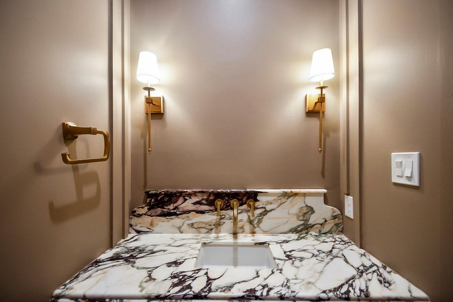 The stylish powder bath makes a lasting impression with elevated designer details and sophisticated finishes perfect for guests.