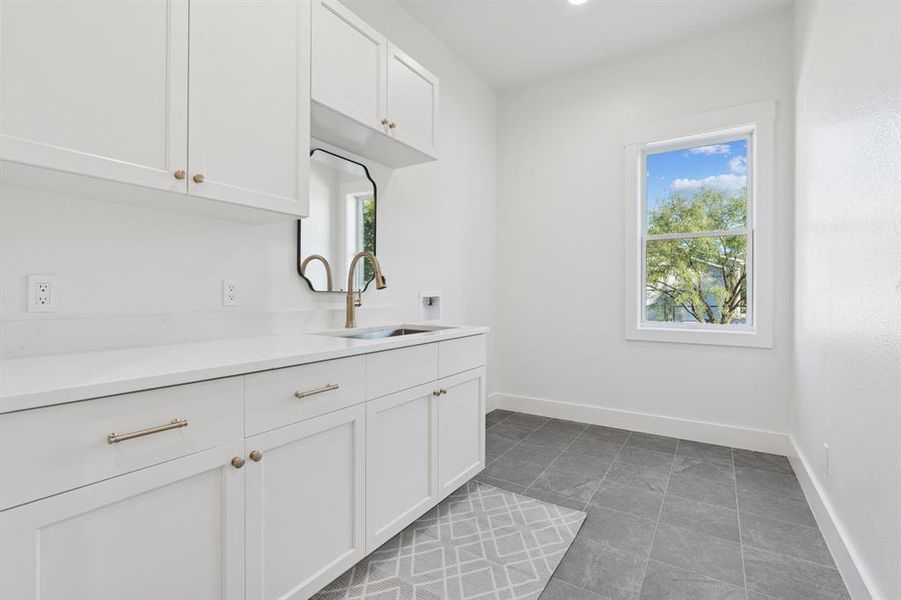 Laundry room with extensive storage and counter space, porcelain tile, utility sink, etc. This room is ALSO fully foam insulated.