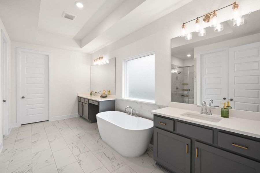 Indulge in this contemporary bathroom featuring a freestanding tub, sleek vanities, and a spacious shower.