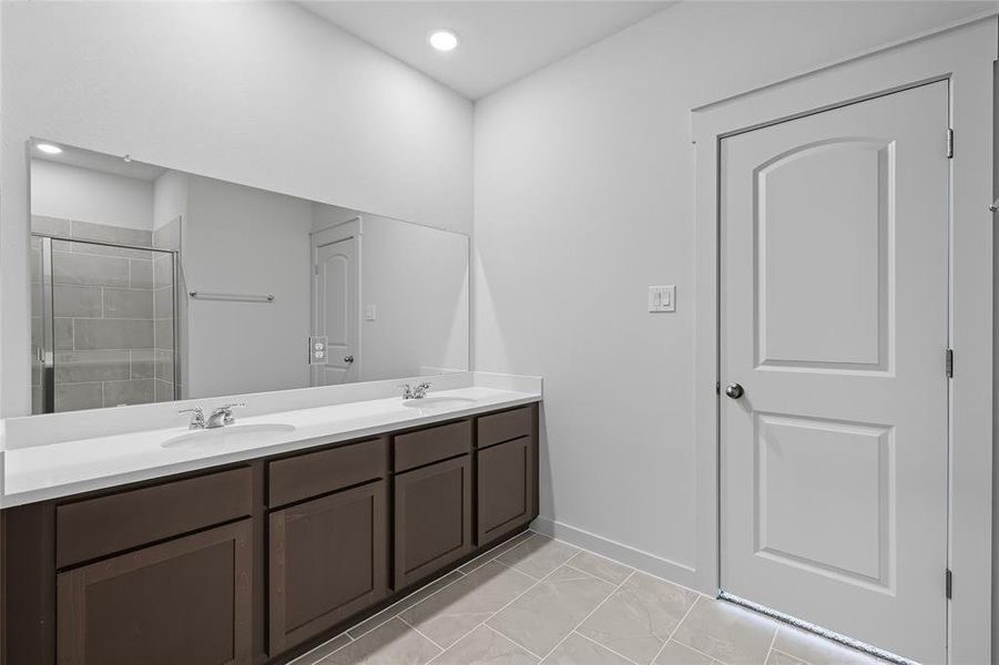 Full bathroom featuring double vanity, a shower stall, light tile patterned flooring, and recessed lighting Full bathroom featuring double vanity, a shower stall, light tile patterned flooring, and recessed lighting