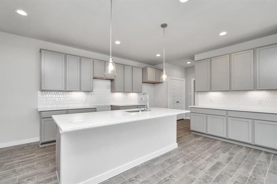 Discover another perspective of this stunning kitchen, generously appointed with an abundance of counter space. Sample photo of completed home with similar floor plan. As-built interior colors and selections may vary.