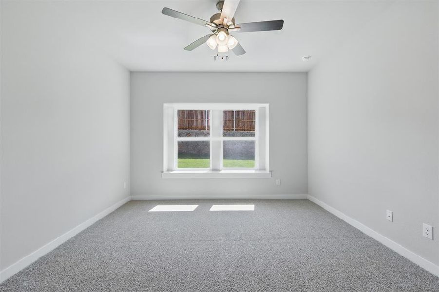Unfurnished room featuring light carpet and a ceiling fan