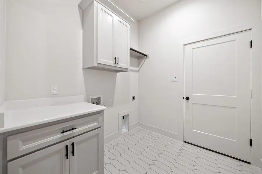 Laundry room featuring hookup for an electric dryer, hookup for a washing machine, cabinet space, and light flooring