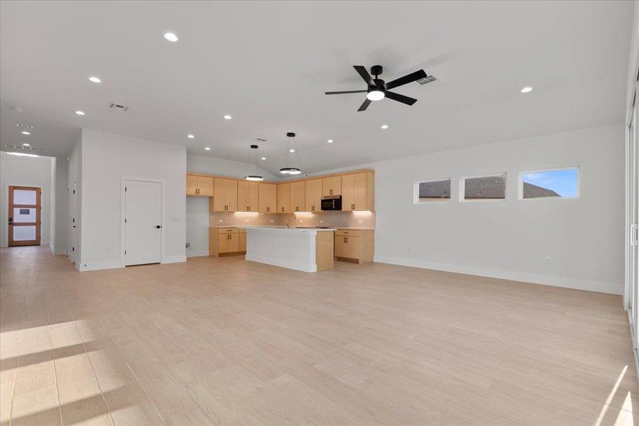 Unfurnished living room featuring light wood-type flooring, ceiling fan, and recessed lighting Unfurnished living room featuring light wood-type flooring, ceiling fan, and recessed lighting