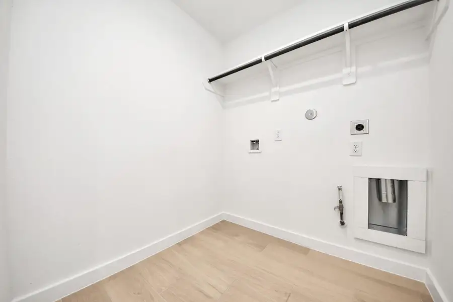 A perfect blend of functionality and comfort. Capture the essence of easy living with a first-floor laundry room, thoughtfully equipped with shelving for effortless organization. Both electric and gas connections available. Sample photo of completed home with similar floor plan. Actual colors and selections may vary.