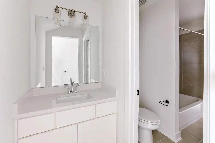 Bathroom featuring toilet, vanity, tile patterned flooring, and shower / bathtub combination Bathroom featuring toilet, vanity, tile patterned flooring, and shower / bathtub combination
