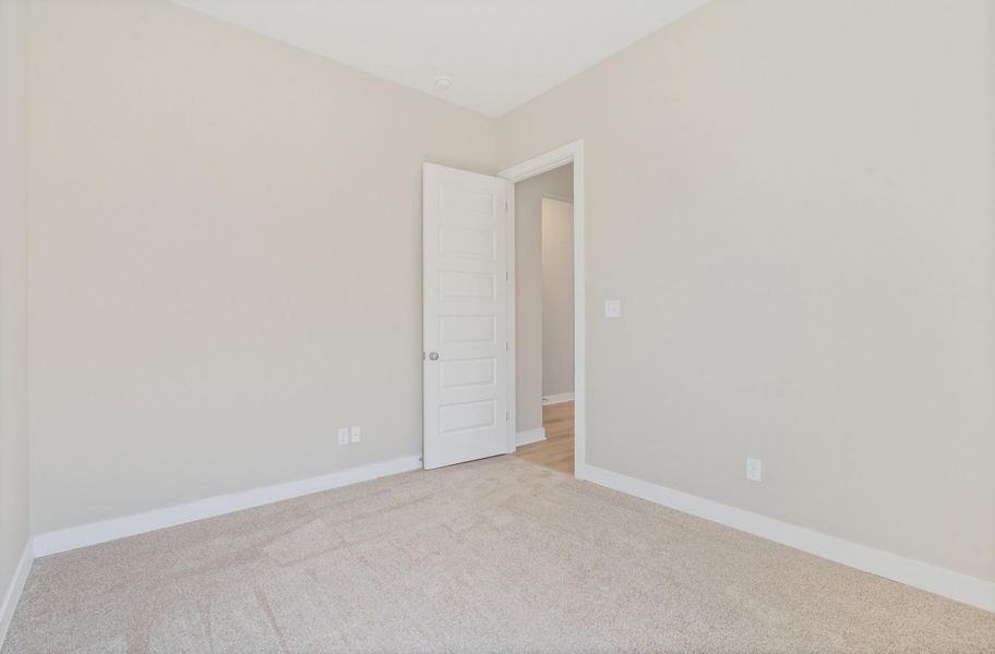 Spare room with baseboards and light carpet