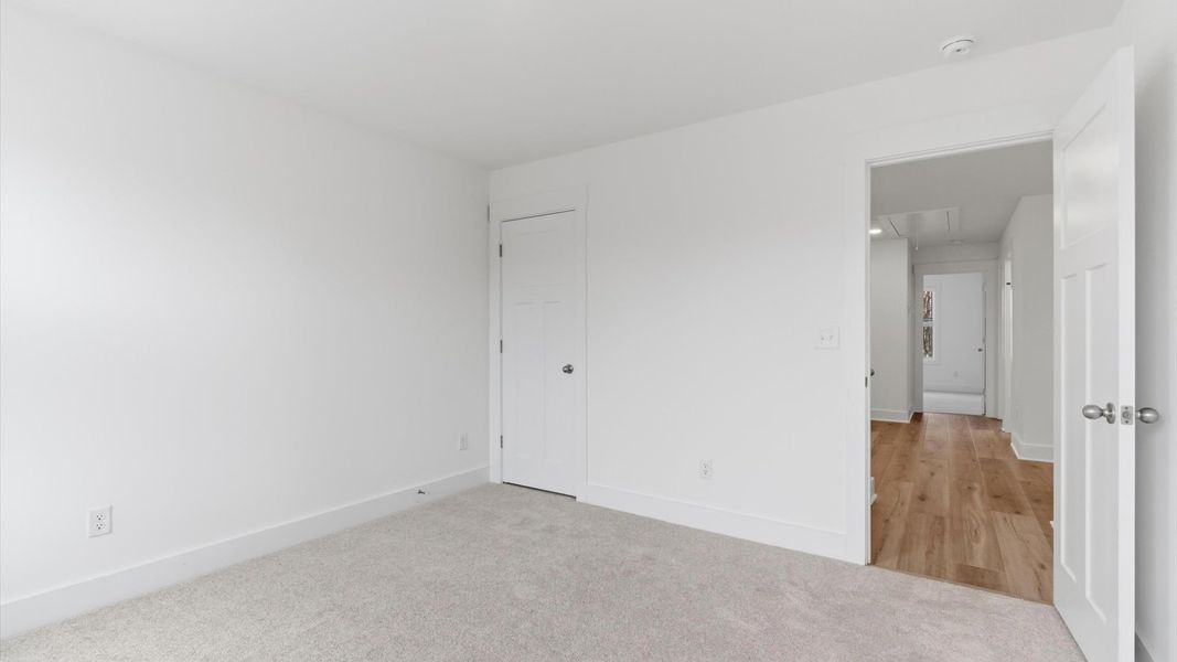 Elegant bedroom retreat featuring soft carpeting and a thoughtfully designed walk-in closet