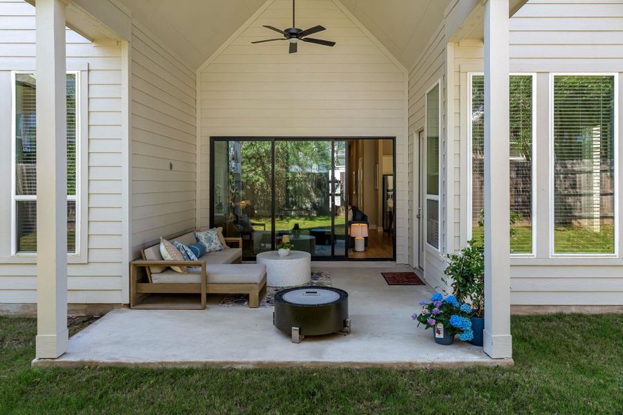 Covered patio featuring a sloped ceiling, ceiling fan, and concrete flooring