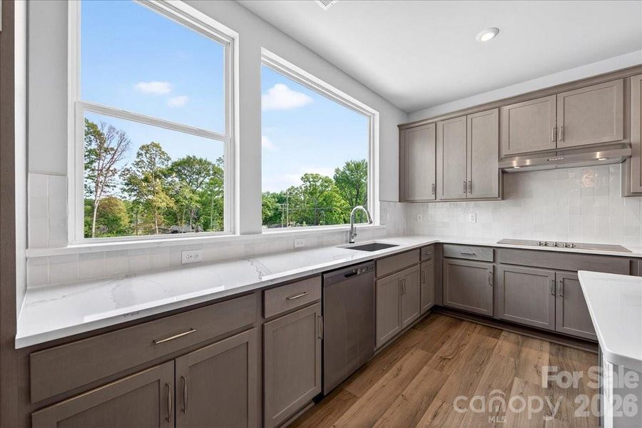 Gourmet kitchen with brown cabinets paired with white quartz countertops
