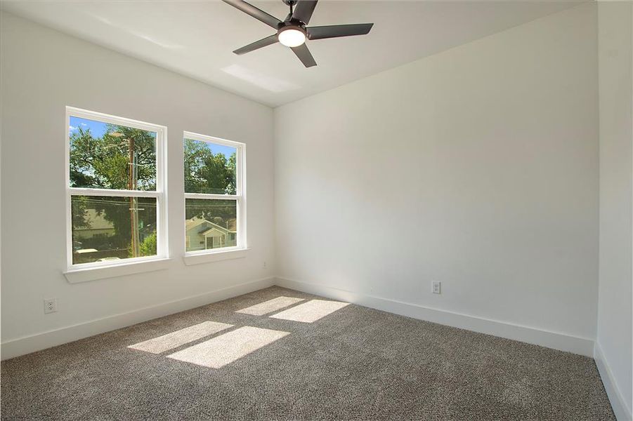 Carpeted spare room with ceiling fan