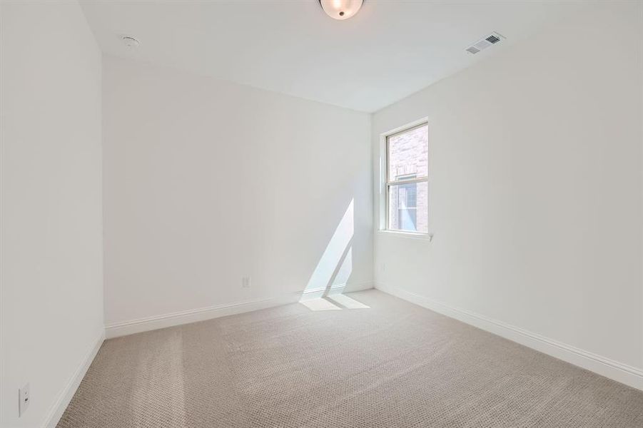 Secondary bedroom with carpet flooring