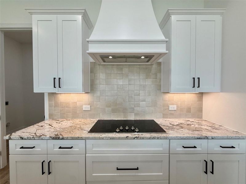 Modern kitchen featuring white shaker cabinetry with matte black hardware