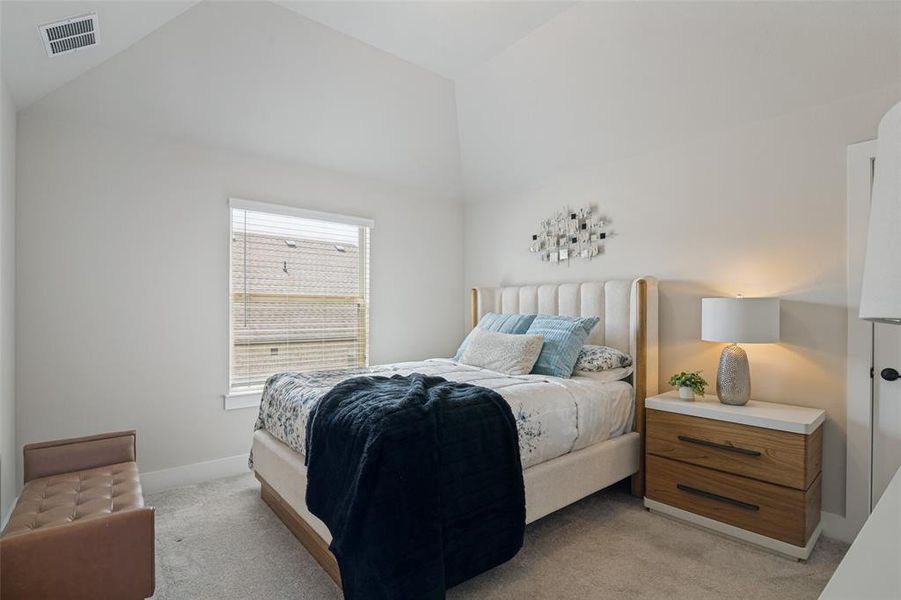 Vaulted ceiling bedroom featuring plush carpet flooring and a single window with horizontal blinds