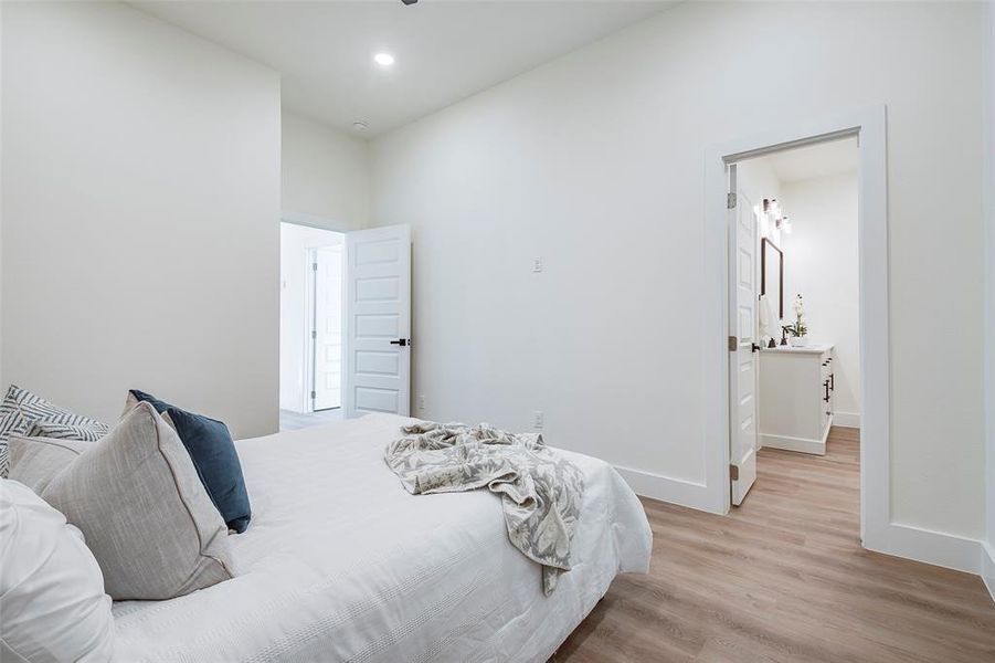 Bedroom featuring ensuite bathroom and light hardwood / wood-style floors