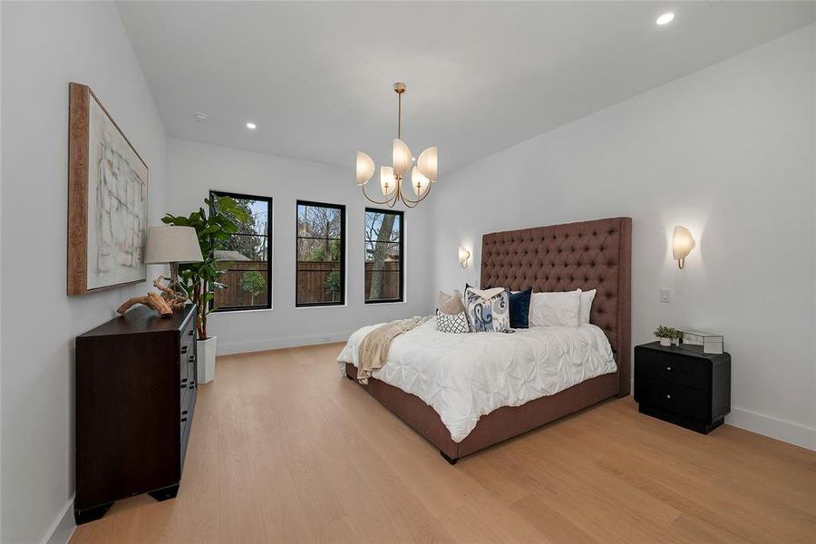 Bedroom featuring light wood-type flooring and hanging lights Bedroom featuring light wood-type flooring and hanging lights