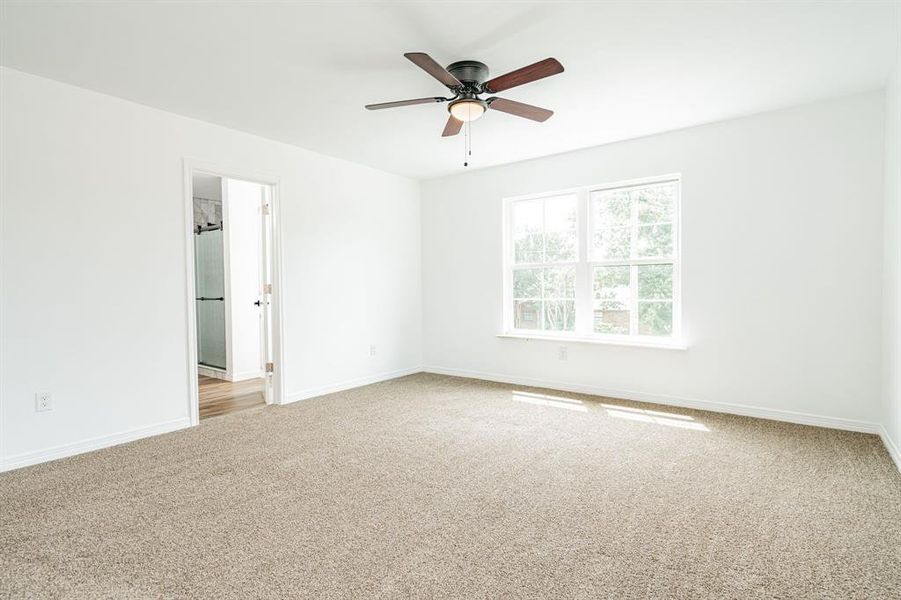 Unfurnished room with light colored carpet and ceiling fan