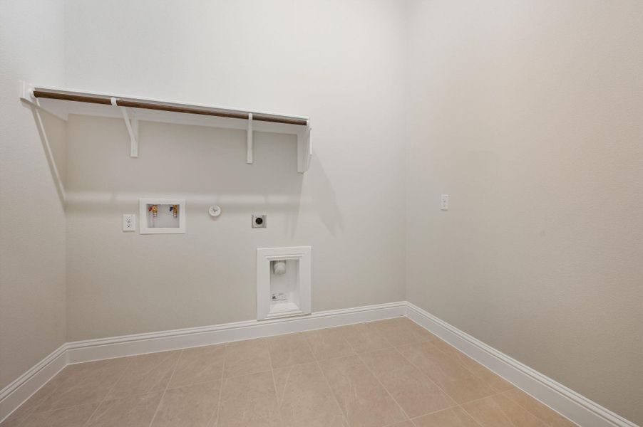 Washroom with hookup for an electric dryer, hookup for a washing machine, hookup for a gas dryer, and light tile patterned floors Washroom with hookup for an electric dryer, hookup for a washing machine, hookup for a gas dryer, and light tile patterned floors