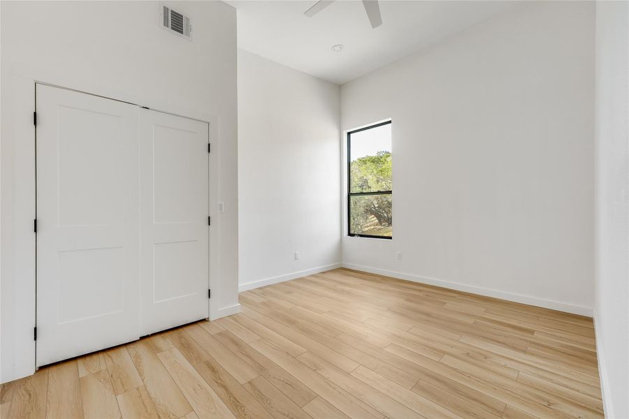 Unfurnished bedroom featuring light wood-type flooring, a ceiling fan, and a closet Unfurnished bedroom featuring light wood-type flooring, a ceiling fan, and a closet