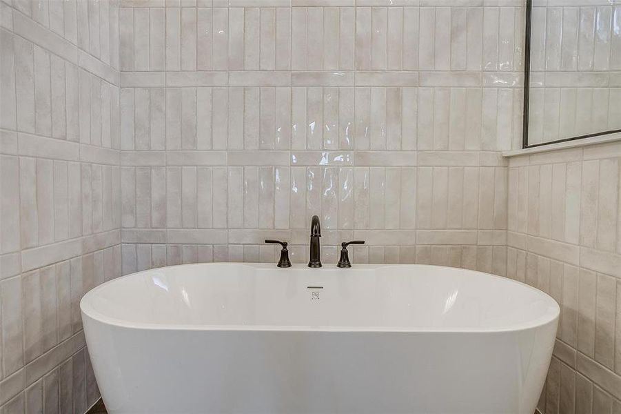 Bathroom featuring a bathtub and tile walls