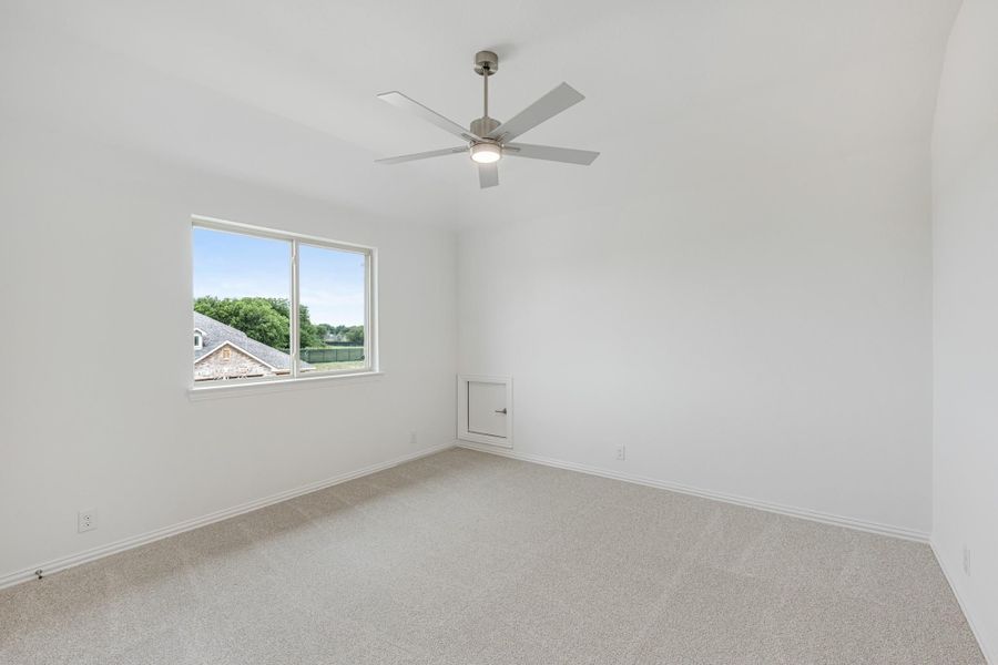 Empty bedroom with carpet flooring, ceiling fan, and a window with outdoor views Empty bedroom with carpet flooring, ceiling fan, and a window with outdoor views