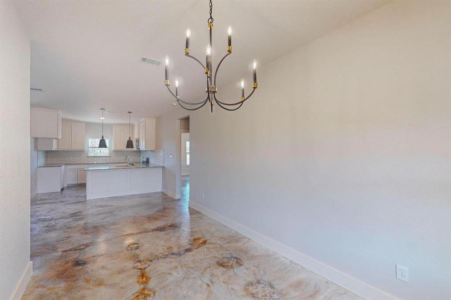 Unfurnished dining area featuring sink and a notable chandelier