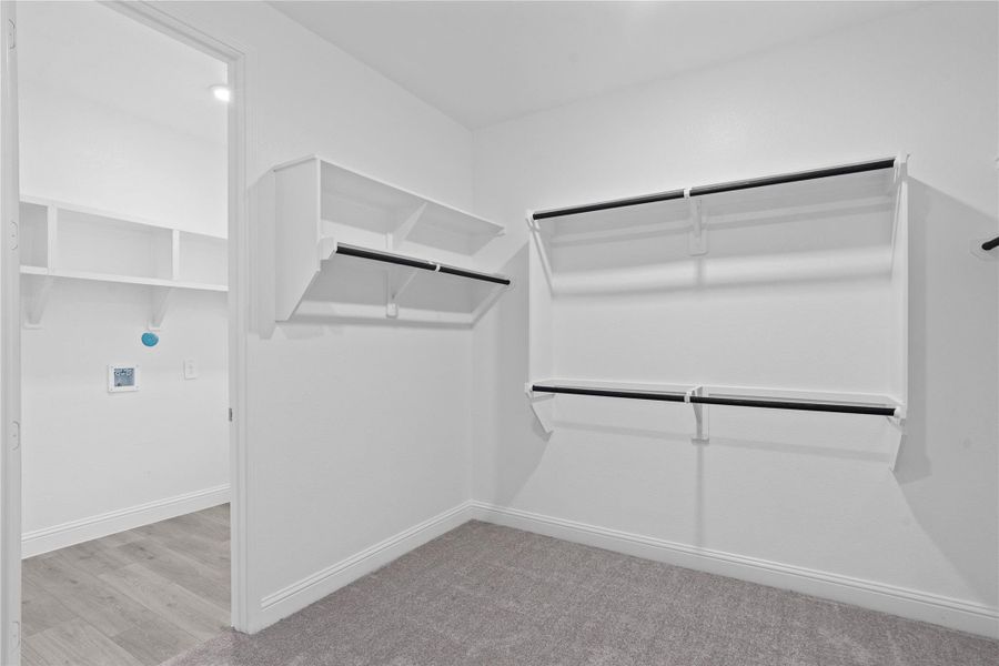 Look at this immaculate closet! With high shelving, multiple rows to hang clothing, you are sure to have enough room for all your belongings! Additional feature is the easy access into the laundry room from primary walk-in closet. Look at this immaculate closet! With high shelving, multiple rows to hang clothing, you are sure to have enough room for all your belongings! Additional feature is the easy access into the laundry room from primary walk-in closet.
