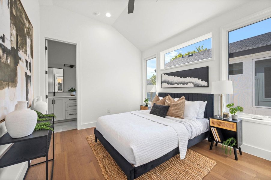 Bedroom with vaulted ceiling, light wood finished floors, connected bathroom, recessed lighting, and a ceiling fan
