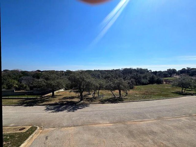 View of asphalt road featuring curbs and a view of countryside
