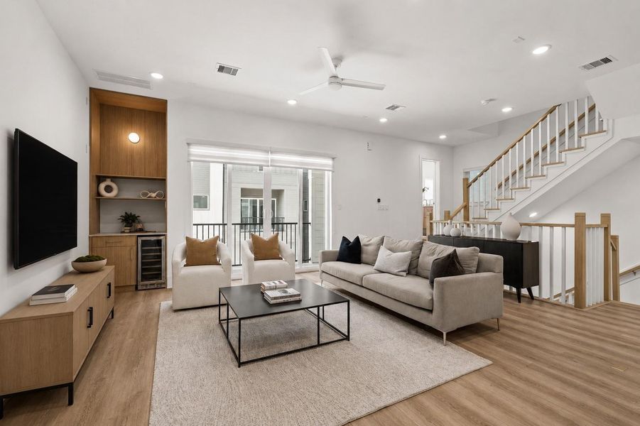 The heart of the home unfolds through an expansive open-concept layout, where elevated ceilings, abundant natural light, and seamless transitions between the living, dining, and kitchen spaces create an inviting sense of openness.