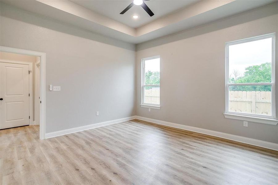 Spare room with ceiling fan, baseboards, and light wood-type flooring Spare room with ceiling fan, baseboards, and light wood-type flooring
