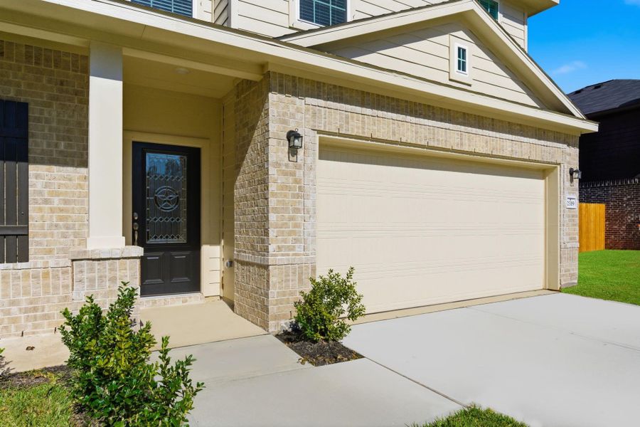 Porch LightsWelcome home to this beautiful two-story Trinity Floor Plan by CastleRock Communities, located in the gated golf-course community of Columbia Lakes! The inviting front porch elevation features elegant brick detailing and a decorative glass front door, offering a warm first impression. The spacious driveway and attached 2-car garage provide convenience and curb appeal, perfectly complementing the home’s modern architectural style.