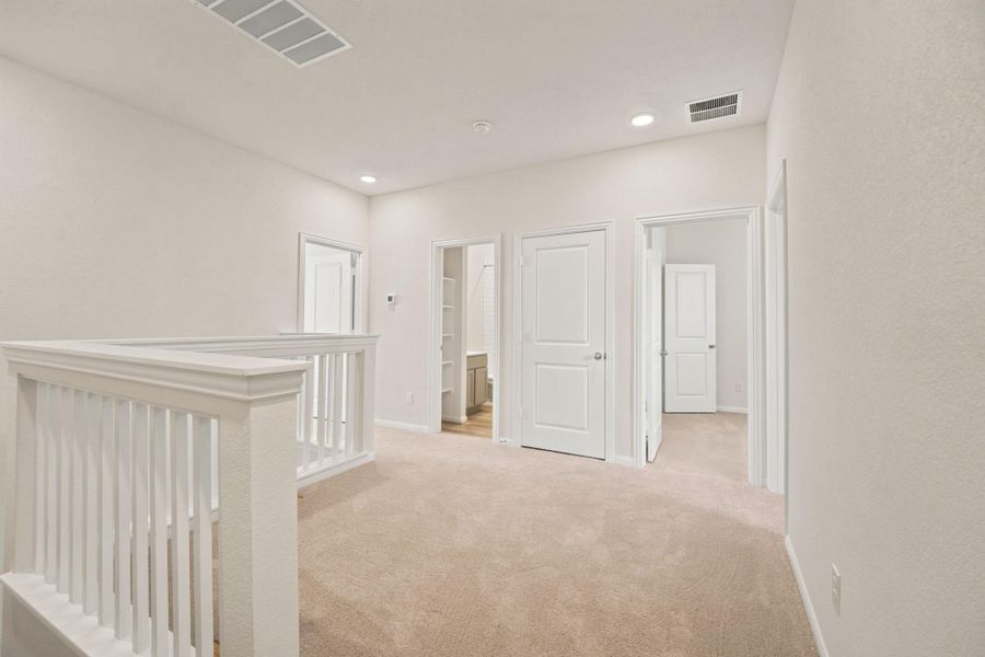 Soft carpeting pairs with crisp white trim in this welcoming upper-level landing space.