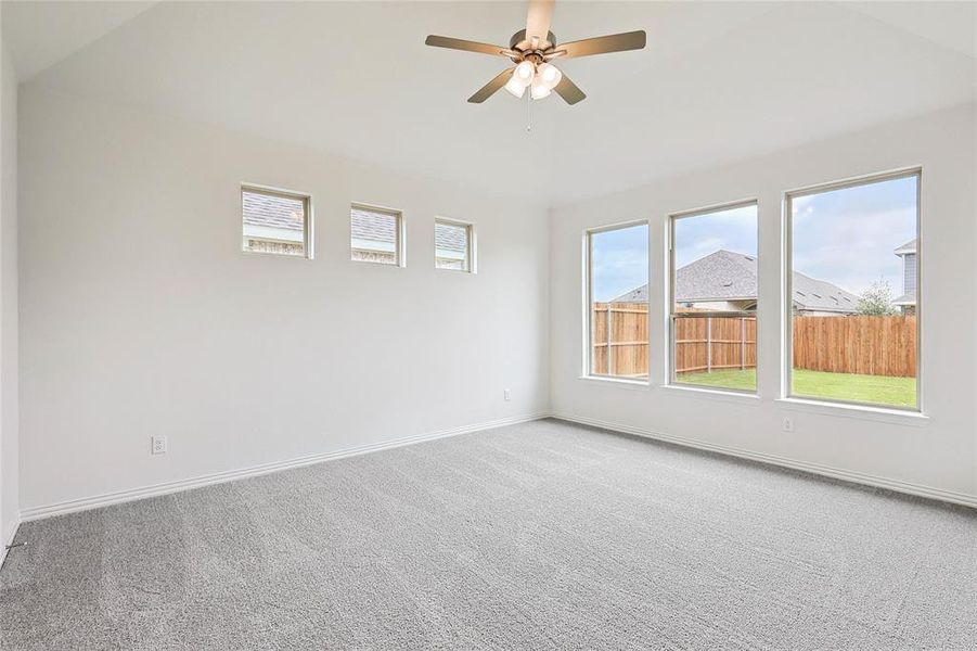 Unfurnished room featuring lofted ceiling, carpet floors, and ceiling fan