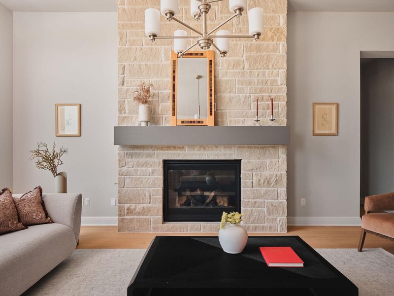 The light-filled living room is anchored by a striking floor-to-ceiling limestone fireplace.