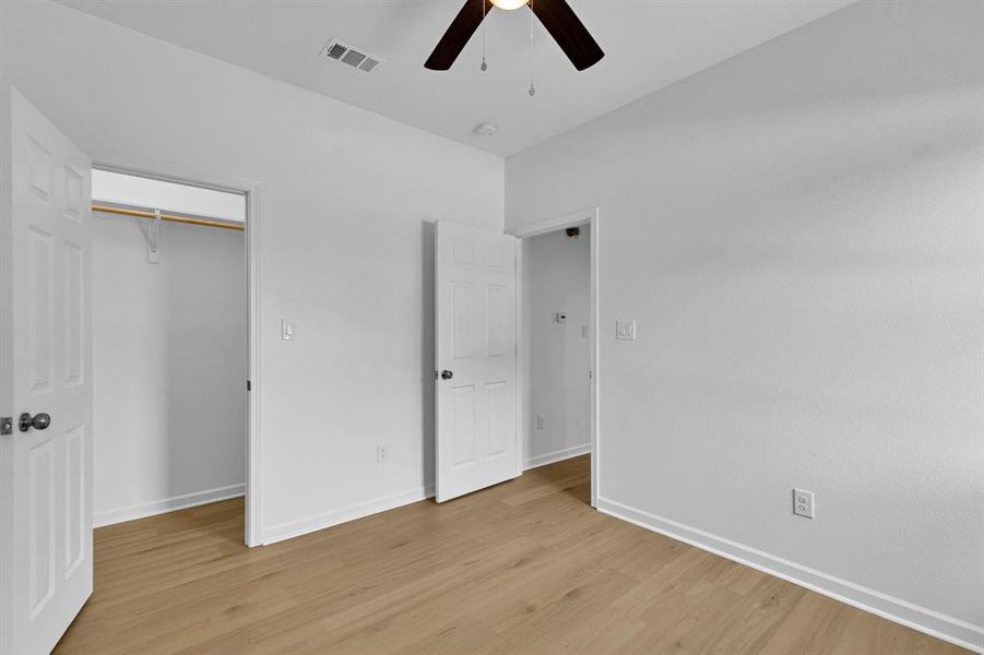 Unfurnished bedroom featuring light wood-style flooring and a ceiling fan Unfurnished bedroom featuring light wood-style flooring and a ceiling fan