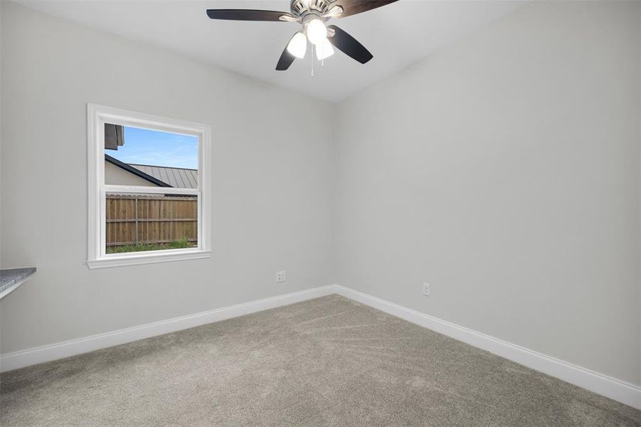 Carpeted spare room with baseboards and ceiling fan Carpeted spare room with baseboards and ceiling fan
