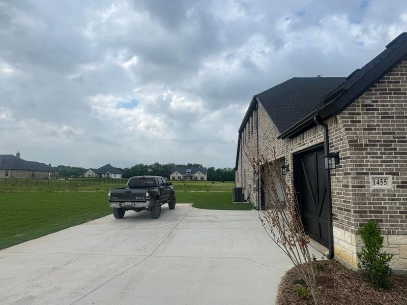 Brick and stone exterior featuring a dark asphalt shingle roof