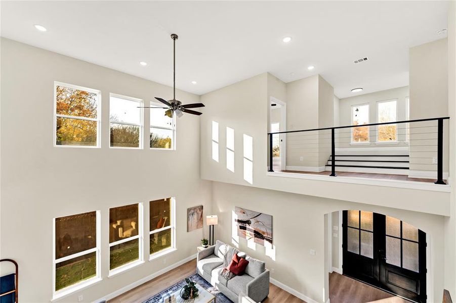 Living room with wood-type flooring, french doors, ceiling fan, and a healthy amount of sunlight