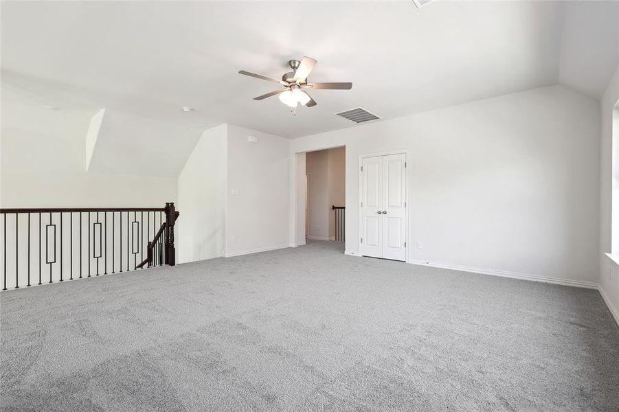 Bonus room with ceiling fan, carpet, and lofted ceiling