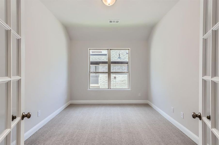 Carpeted spare room featuring lofted ceiling