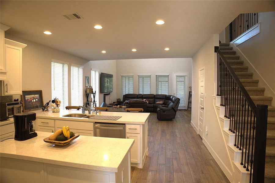 Kitchen with white cabinets, open floor plan, dishwasher, dark wood-style floors, and recessed lighting Kitchen with white cabinets, open floor plan, dishwasher, dark wood-style floors, and recessed lighting