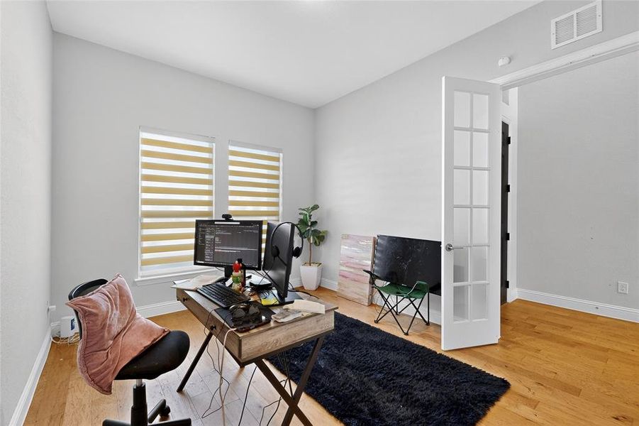 Office area with light wood-style flooring and baseboards
