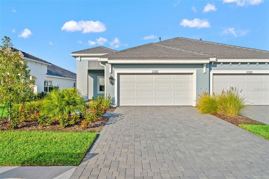 Front exterior of a new home in Palm Grove, Lakewood Ranch, FL, highlighting curb appeal (Image 2). Front exterior of a new home in Palm Grove, Lakewood Ranch, FL, highlighting curb appeal (Image 2).